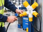 Industrial Multi Plug connected with power cables in a factory workspace for equipment and maintenance use.